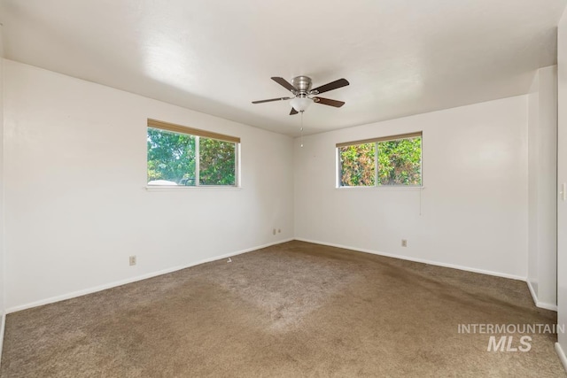 carpeted spare room featuring healthy amount of natural light, baseboards, and ceiling fan