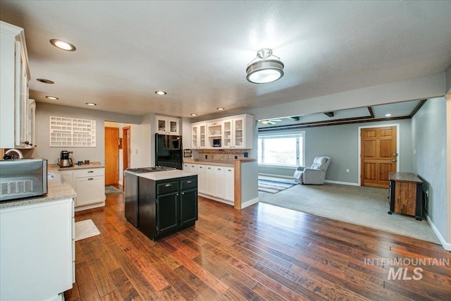 kitchen with a center island, baseboards, white cabinetry, and fridge