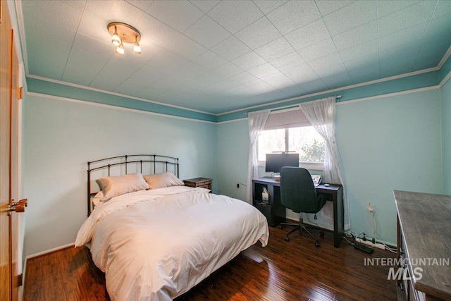 bedroom featuring wood finished floors and crown molding