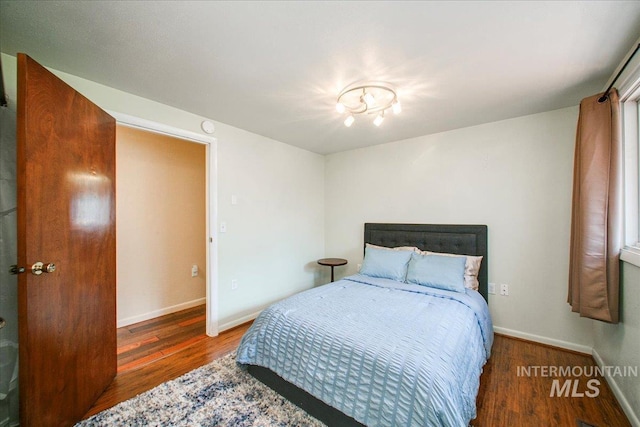 bedroom with baseboards and wood finished floors