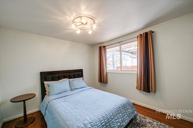 bedroom featuring baseboards and wood finished floors