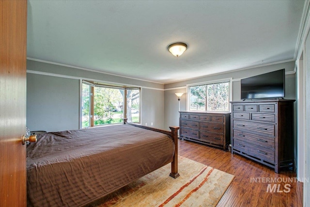 bedroom featuring wood finished floors and crown molding