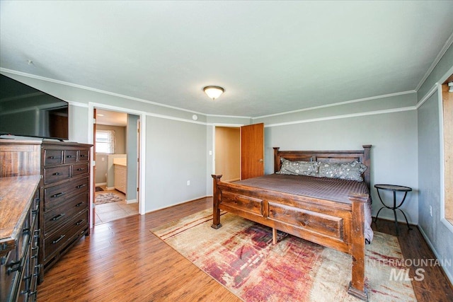 bedroom with baseboards, wood finished floors, and crown molding