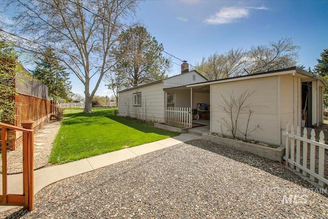 view of front of home featuring a chimney, a front yard, and fence