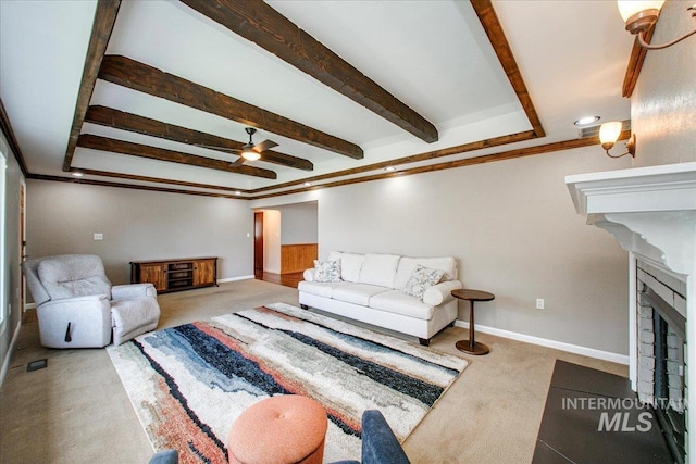 living area with a fireplace with flush hearth, carpet floors, baseboards, and ceiling fan