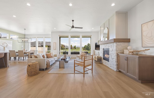 5222 S Montague Way, Meridian, ID 83642 - living room featuring light wood-style flooring, a fireplace, ceiling fan, a chandelier, and recessed lighting