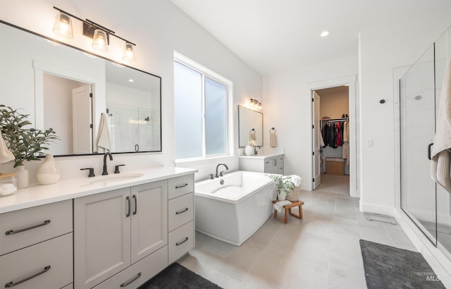 5222 S Montague Way, Meridian, ID 83642 - bathroom featuring a stall shower, two vanities, a walk in closet, a freestanding tub, and recessed lighting