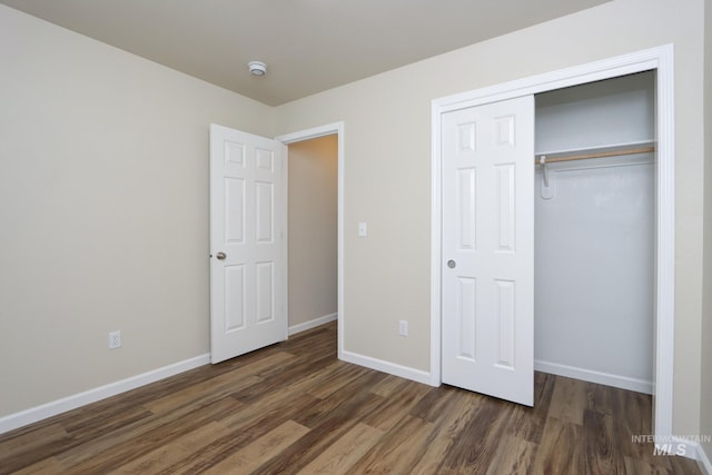 unfurnished bedroom with a closet, baseboards, and wood finished floors