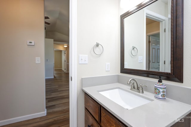 bathroom with baseboards, wood finished floors, and vanity