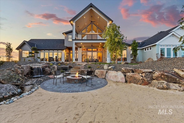 rear view of house with an outdoor fire pit, a patio, and a balcony