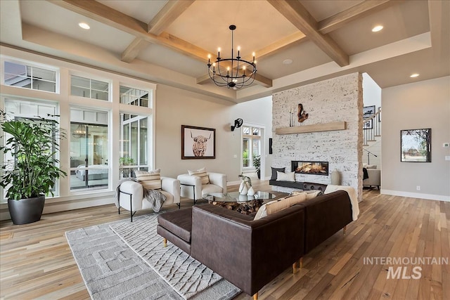 living area with baseboards, a chandelier, a multi sided fireplace, coffered ceiling, and hardwood / wood-style flooring