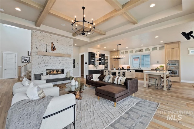 living room featuring a notable chandelier, light wood-type flooring, a multi sided fireplace, and coffered ceiling