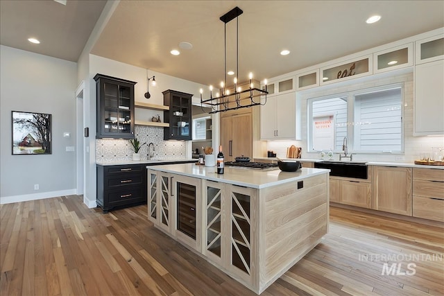 kitchen featuring a center island, a sink, open shelves, and decorative backsplash