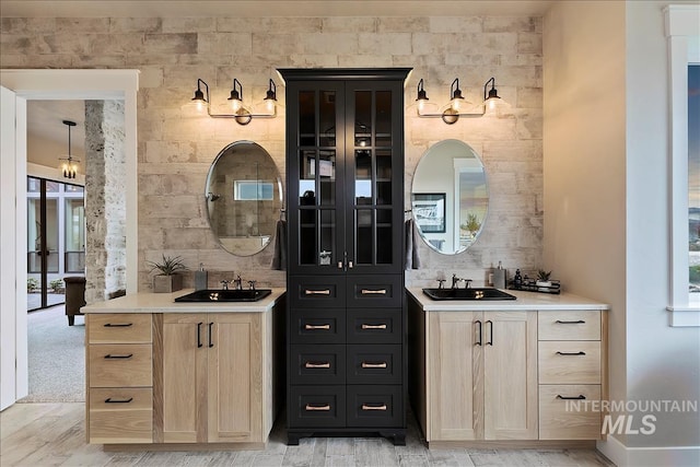 bar featuring light wood-style flooring, wet bar, and a sink