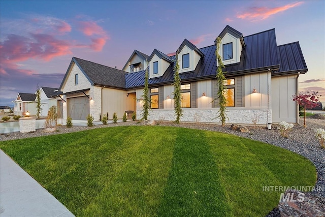 modern inspired farmhouse with stone siding, a front lawn, a garage, a standing seam roof, and metal roof