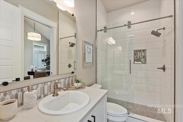 full bathroom featuring toilet, a stall shower, and vanity