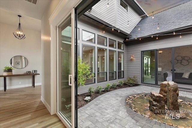 view of exterior entry with a shingled roof