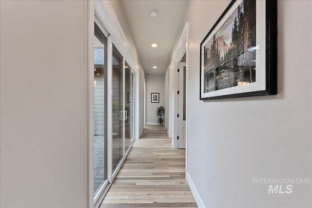 hallway featuring recessed lighting, light wood-style floors, and baseboards