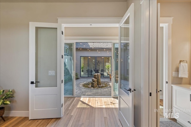 entryway featuring french doors, baseboards, and wood finished floors