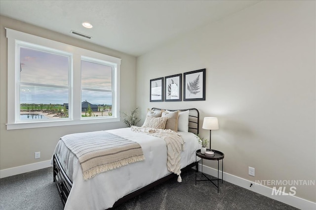 bedroom featuring dark colored carpet, visible vents, and baseboards