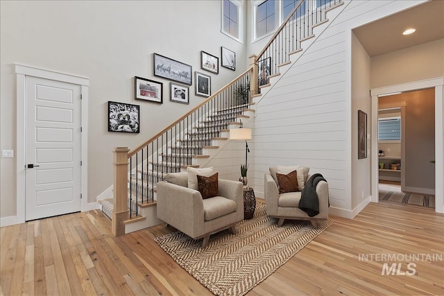 stairway with recessed lighting, wood-type flooring, and baseboards