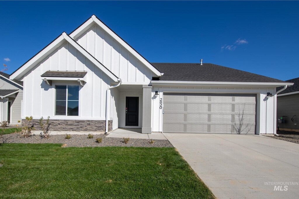 17586 N Window Peak Way, Nampa, ID 83687 - modern farmhouse style home featuring board and batten siding, a front yard, an attached garage, concrete driveway, and stone siding