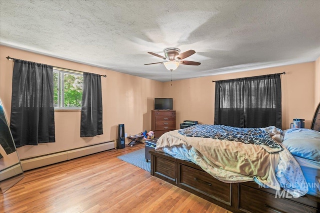 bedroom with wood finished floors, a ceiling fan, a textured ceiling, and a baseboard heating unit