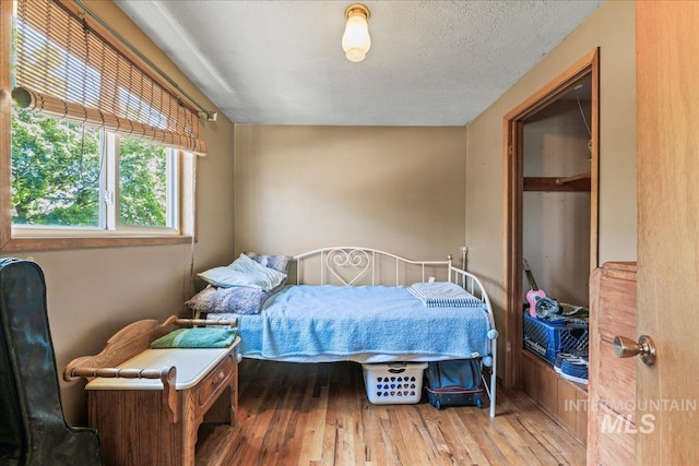 bedroom with a textured ceiling and hardwood / wood-style flooring