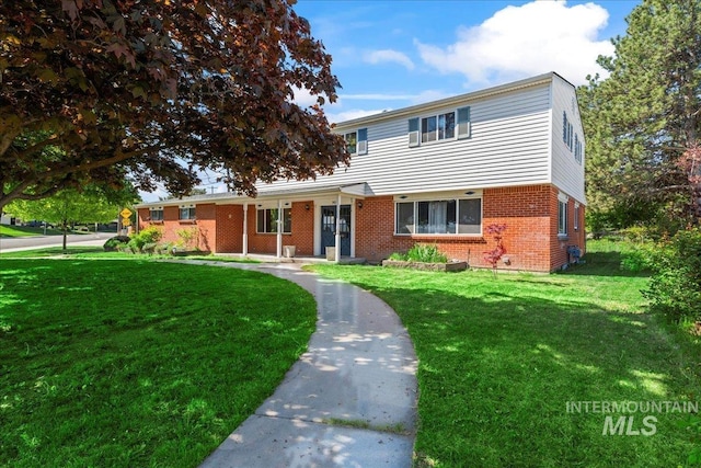 traditional-style house featuring brick siding and a front lawn