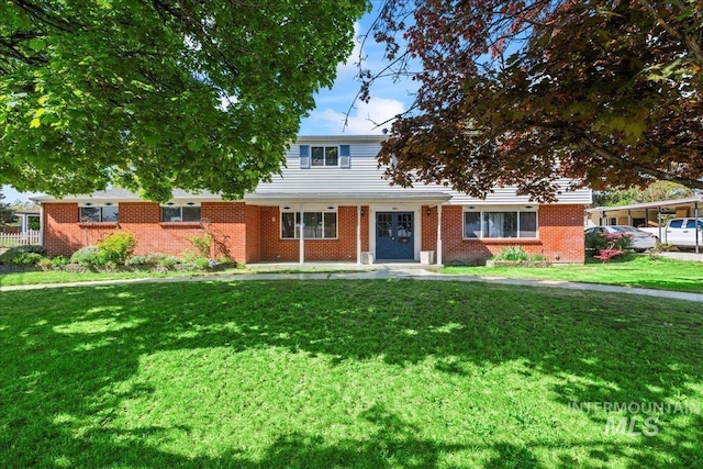 traditional-style home featuring brick siding and a front yard