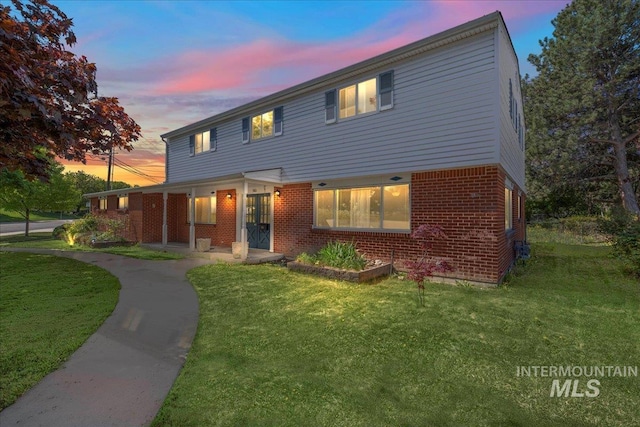 view of front facade with a front yard and brick siding