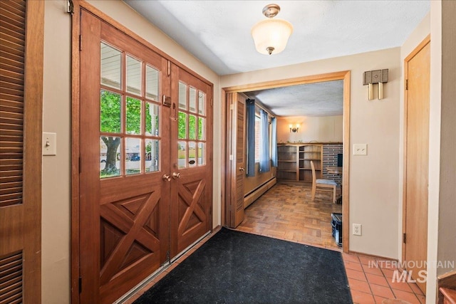 doorway to outside with baseboards and a baseboard heating unit