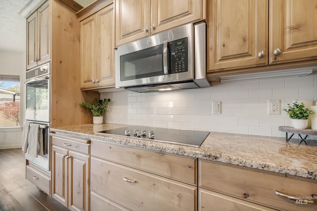 8235 W Tether St, Boise, ID 83709 - kitchen with stainless steel microwave, double oven, black electric stovetop, and backsplash