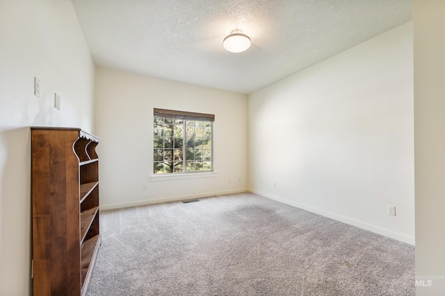 8235 W Tether St, Boise, ID 83709 - unfurnished living room featuring carpet flooring, baseboards, and a textured ceiling