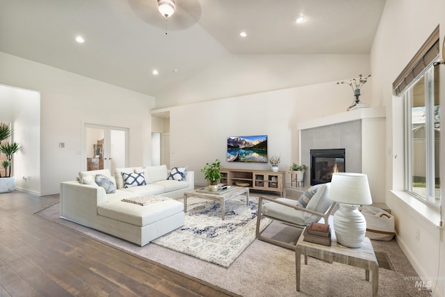 8235 W Tether St, Boise, ID 83709 - living area with high vaulted ceiling, wood finished floors, a tiled fireplace, a ceiling fan, and recessed lighting