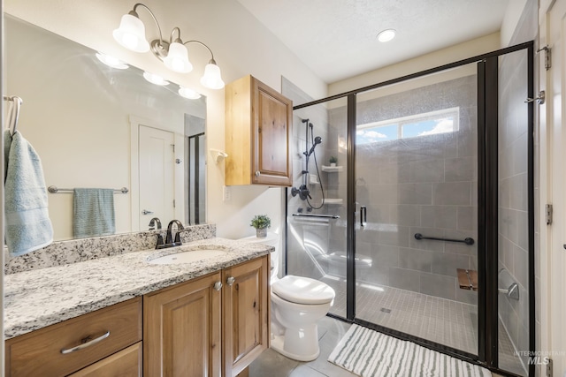 8235 W Tether St, Boise, ID 83709 - bathroom featuring vanity, toilet, a shower stall, and tile patterned flooring
