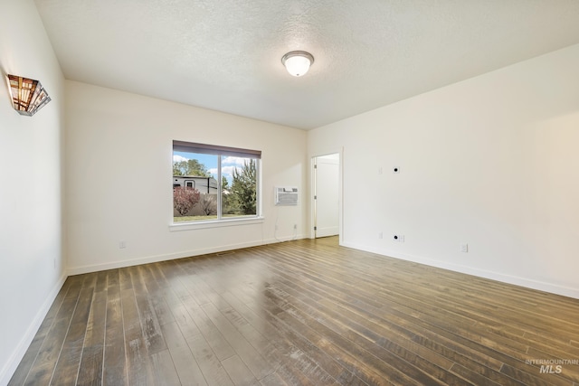 8235 W Tether St, Boise, ID 83709 - unfurnished room with dark wood-style floors, baseboards, a wall mounted air conditioner, and a textured ceiling