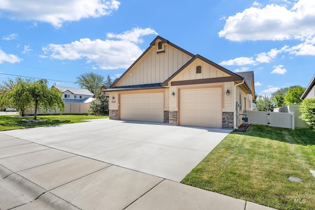 8235 W Tether St, Boise, ID 83709 - view of front facade with board and batten siding, a gate, driveway, an attached garage, and stone siding