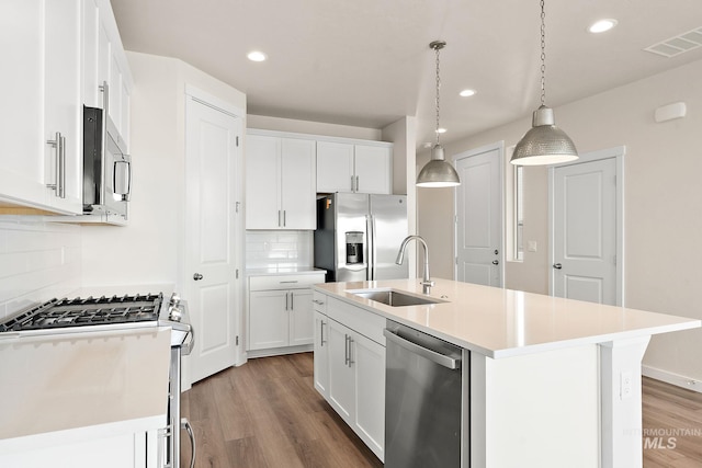 kitchen with visible vents, a sink, light countertops, light wood-style floors, and appliances with stainless steel finishes