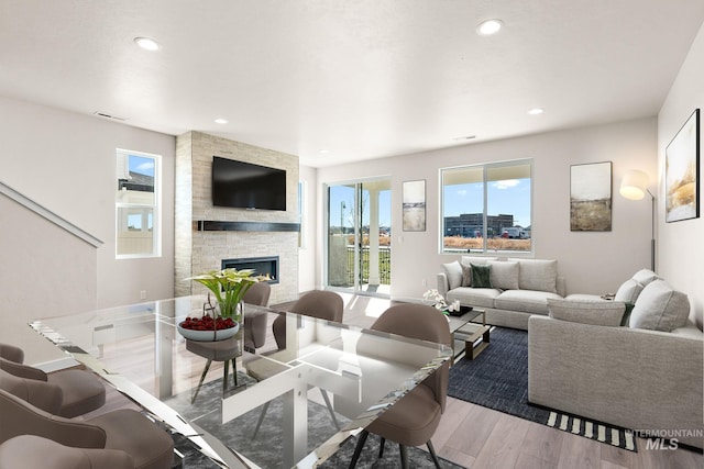 living room with recessed lighting, a fireplace, and wood finished floors