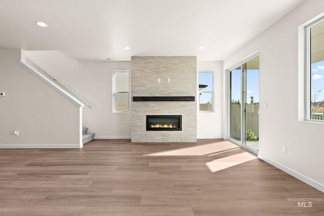 unfurnished living room featuring light wood finished floors, recessed lighting, and baseboards