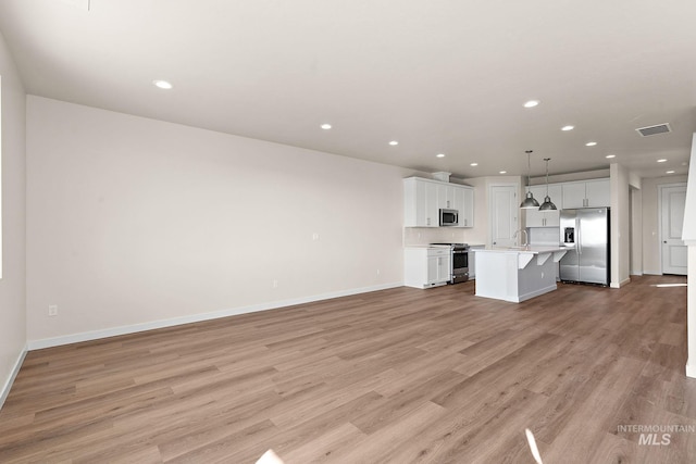 unfurnished living room featuring a sink, visible vents, recessed lighting, and light wood finished floors