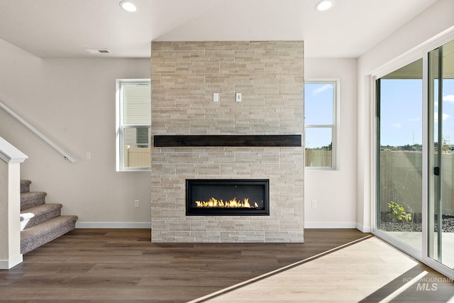 unfurnished living room with visible vents, recessed lighting, baseboards, and wood finished floors