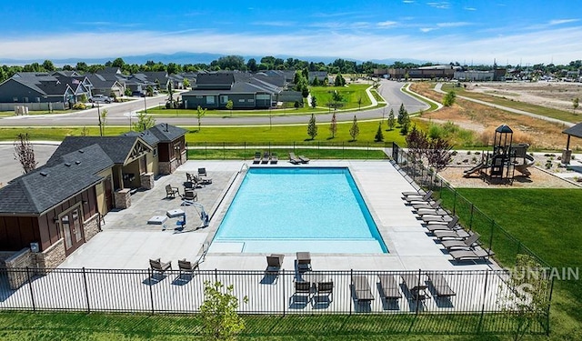 pool featuring a residential view, a patio, a lawn, and fence