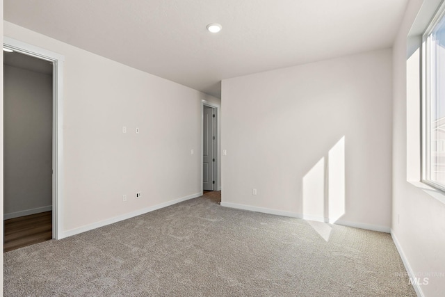 carpeted spare room with baseboards