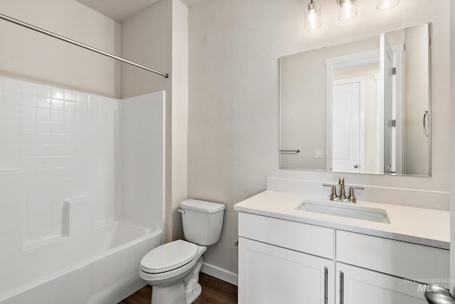 bathroom featuring toilet, wood finished floors, shower / bathing tub combination, baseboards, and vanity