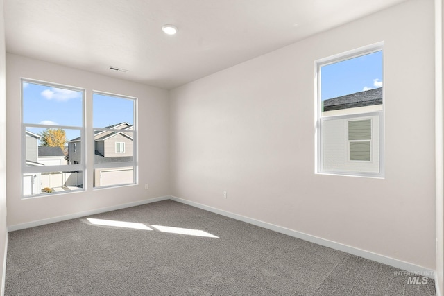 spare room featuring visible vents, baseboards, and carpet