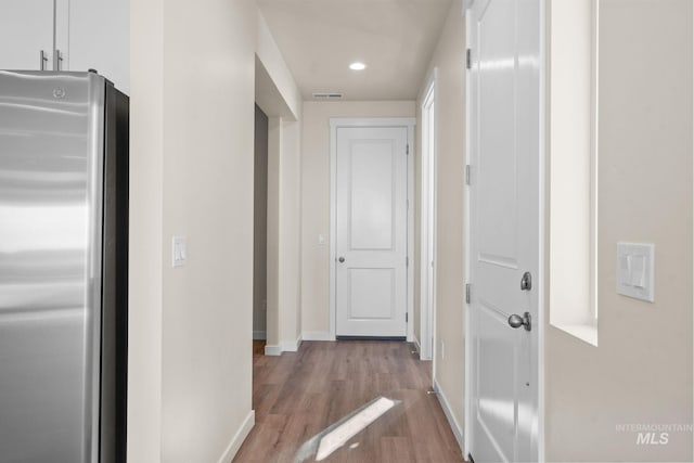 hall with visible vents, recessed lighting, wood finished floors, and baseboards