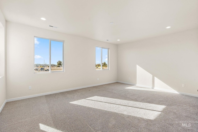 unfurnished room featuring recessed lighting, baseboards, visible vents, and light carpet