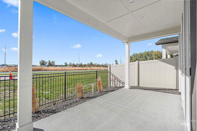 view of patio with a rural view and fence